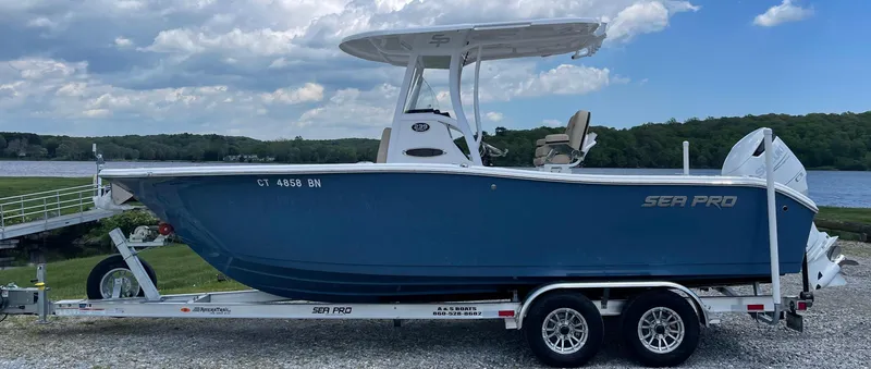 Slide: The Image of 2022 Sea Pro 239 Center Console boat on trailer by a lake, under cloudy sky. - 5