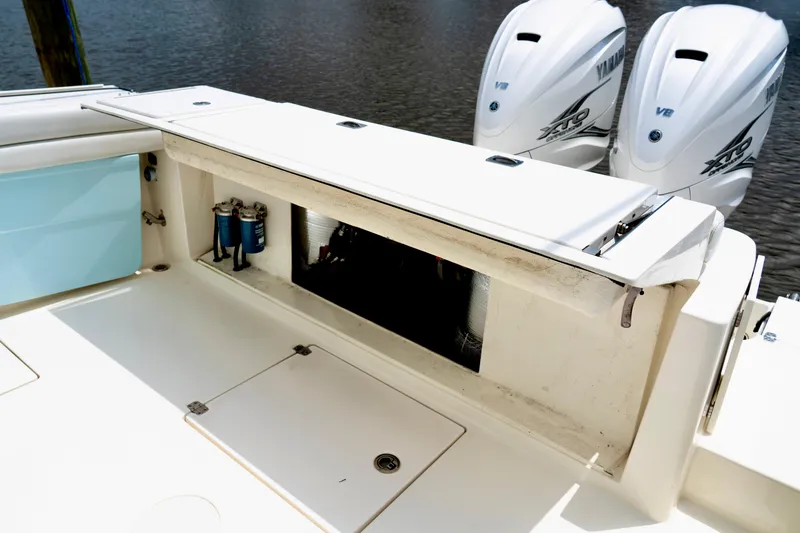 Slide: The Image of 2024 Cobia 350 boat with Yamaha engines, featuring storage compartment and clean deck design. - 10