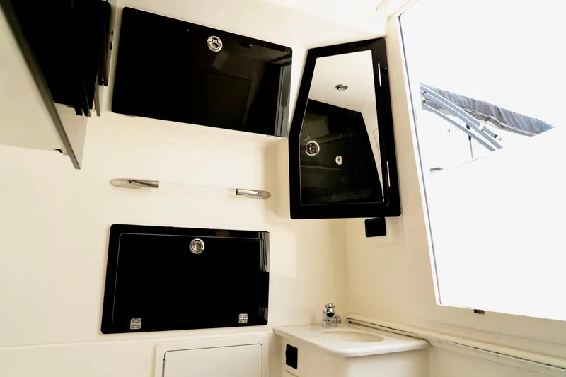 Slide: The Image of 2024 Cobia 350 boat interior with sleek black cabinets and compact sink area. - 17