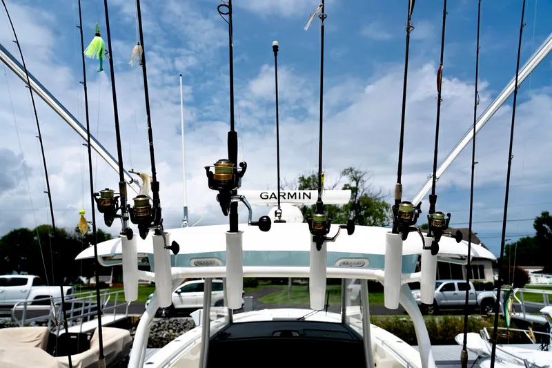 Slide: The Image of Fishing rods on a 2024 Cobia 350 boat, equipped with Garmin technology, under a cloudy sky. - 18