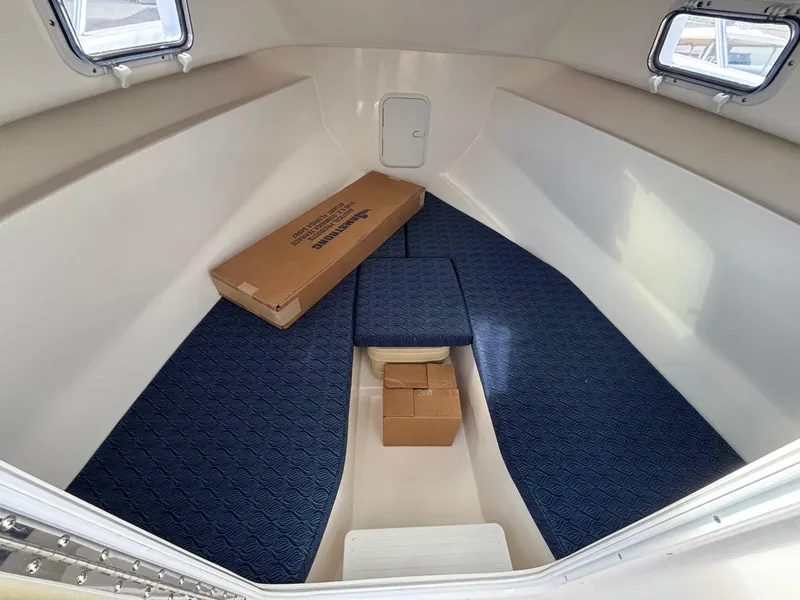 Slide: The Image of Interior cabin of 2026 NorthCoast 235 HT boat with blue cushions and storage boxes. - 10