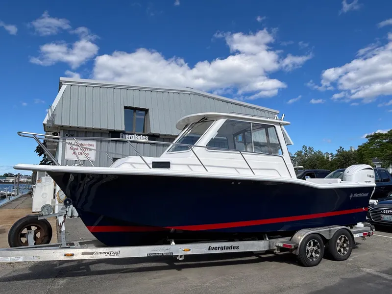 Slide: The Image of 2026 NorthCoast 235 HT boat on trailer, parked outdoors under a clear blue sky. - 3