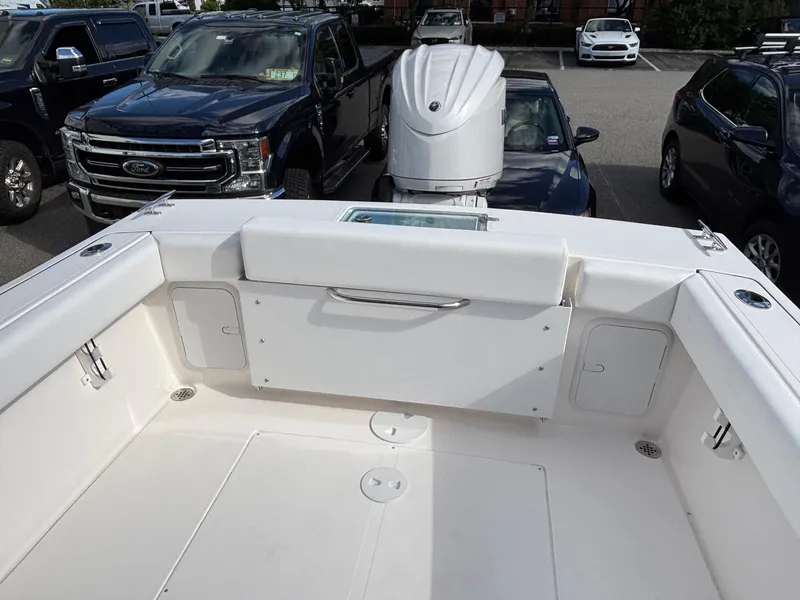 Slide: The Image of 2026 NorthCoast 235 HT boat interior with motor, parked near vehicles. - 4