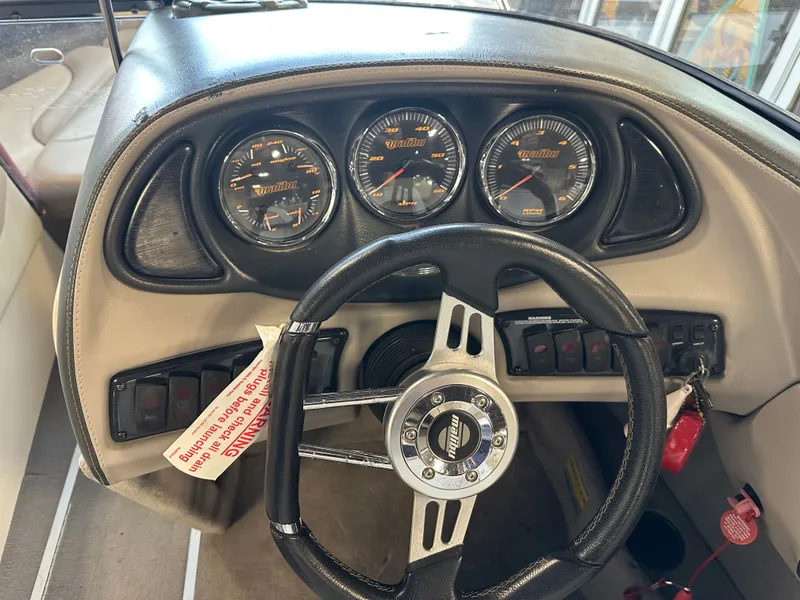Slide: The Image of 2004 Malibu Wakesetter LSV dashboard with steering wheel and gauges. - 11