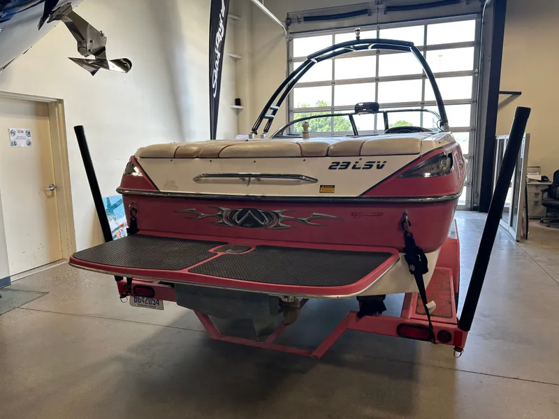 Slide: The Image of 2004 Malibu Wakesetter LSV boat in a garage, rear view with swim platform. - 2