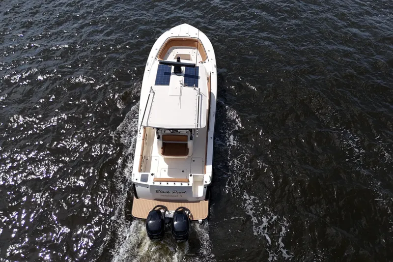 Slide: The Image of 2021 Scout 330 LXF boat cruising on open water, aerial view. - 26