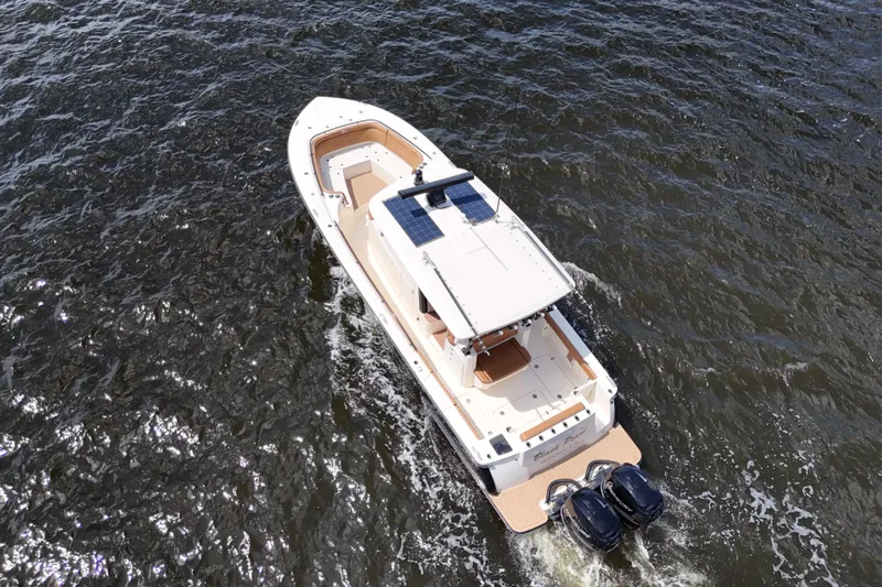 Slide: The Image of 2021 Scout 330 LXF boat cruising on open water, aerial view. - 27
