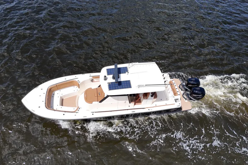 Slide: The Image of 2021 Scout 330 LXF boat cruising on water, aerial view. - 29