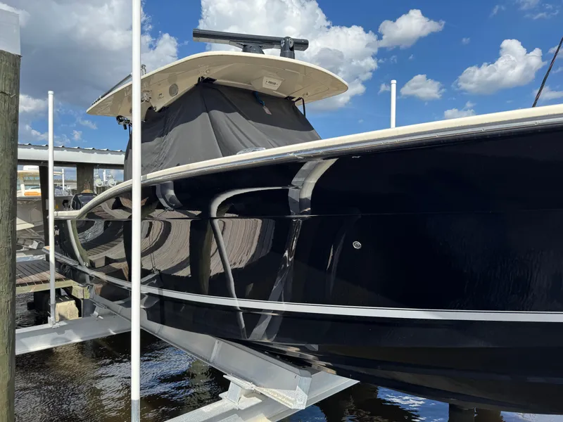 Slide: The Image of 2021 Scout 330 LXF boat docked under a clear blue sky. - 33