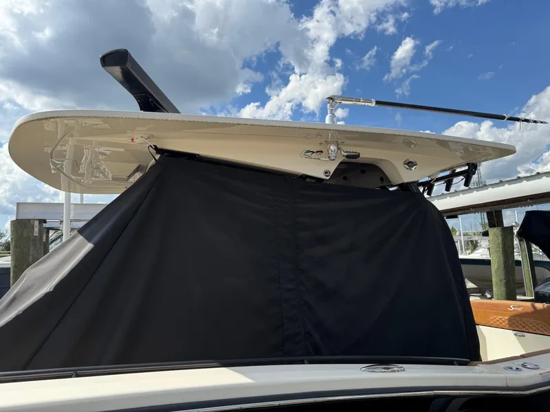 Slide: The Image of 2021 Scout 330 LXF boat with covered deck, under a partly cloudy sky. - 35
