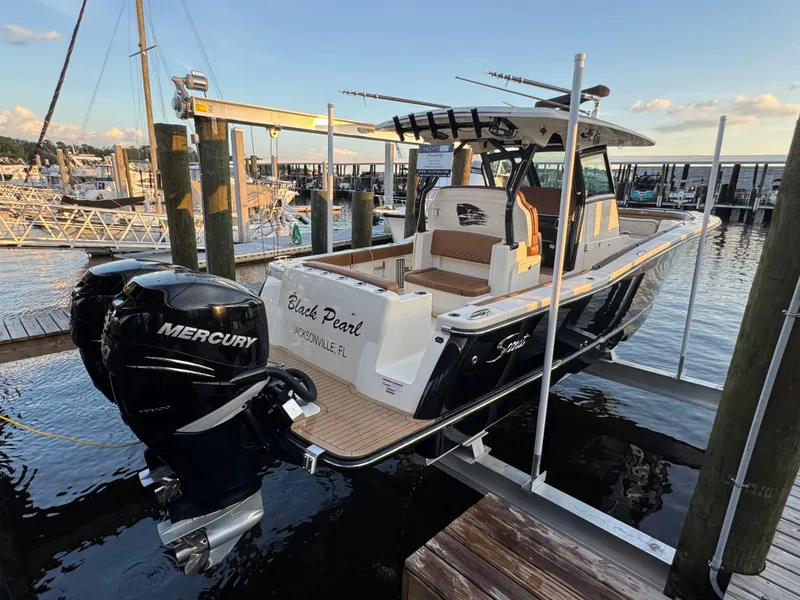 Slide: The Image of 2021 Scout 330 LXF boat docked, featuring dual Mercury engines, named "Black Pearl" in Jacksonville, FL. - 37
