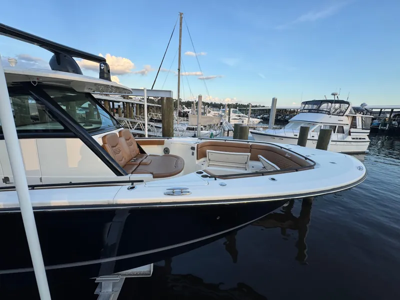 Slide: The Image of 2021 Scout 330 LXF boat docked at marina, featuring sleek design and luxurious seating. - 43