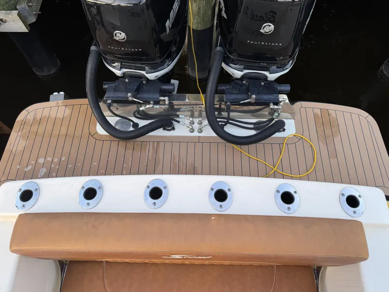 Slide: The Image of 2021 Scout 330 LXF boat deck with dual outboard engines and rod holders. - 47