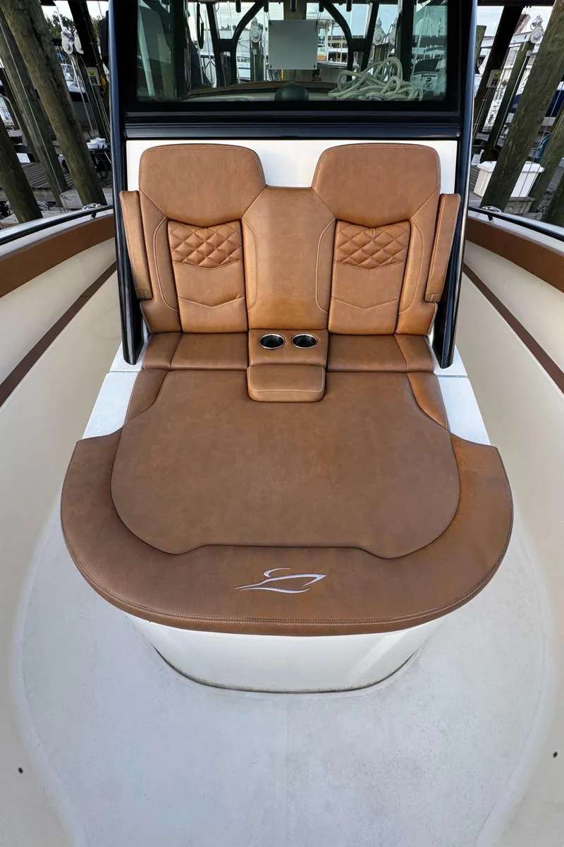 Slide: The Image of 2021 Scout 330 LXF boat interior with luxurious brown leather seating and cup holders. - 56