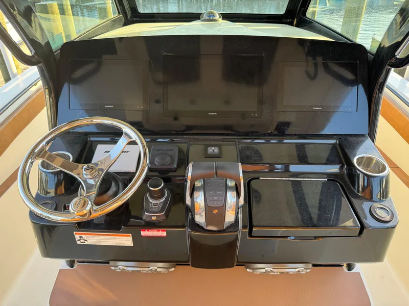 Slide: The Image of 2021 Scout 330 LXF boat dashboard with steering wheel and control panel. - 58