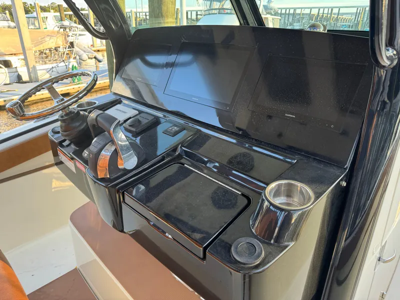 Slide: The Image of 2021 Scout 330 LXF boat dashboard with steering wheel and navigation screens. - 59