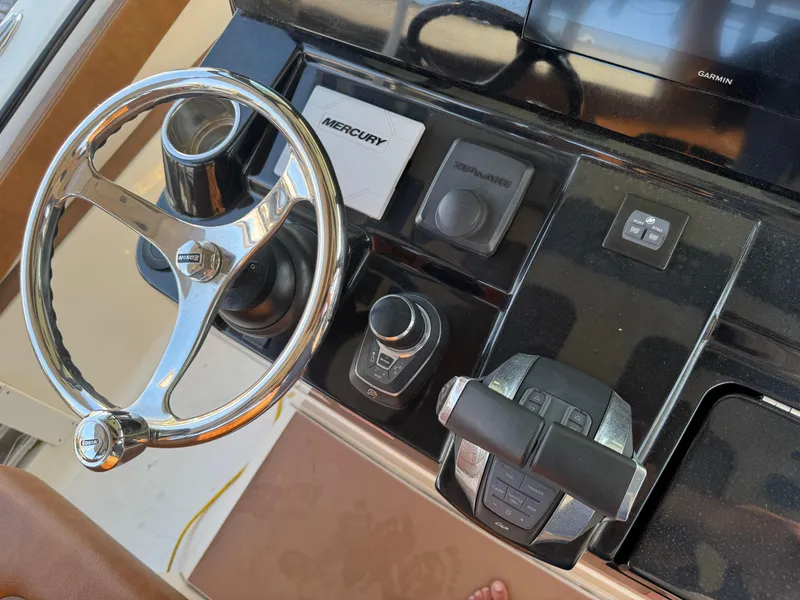 Slide: The Image of 2021 Scout 330 LXF boat dashboard with steering wheel and controls. - 60