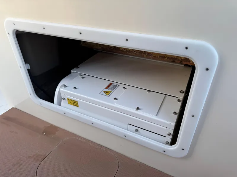 Slide: The Image of Storage compartment on a 2021 Scout 330 LXF boat, featuring a secured white panel. - 63