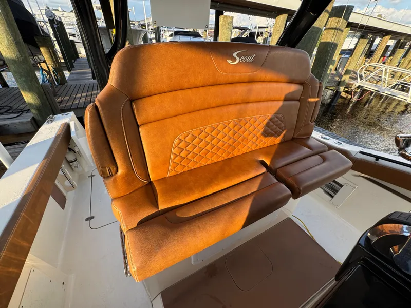 Slide: The Image of Luxurious brown leather seating on a 2021 Scout 330 LXF boat at a marina. - 68