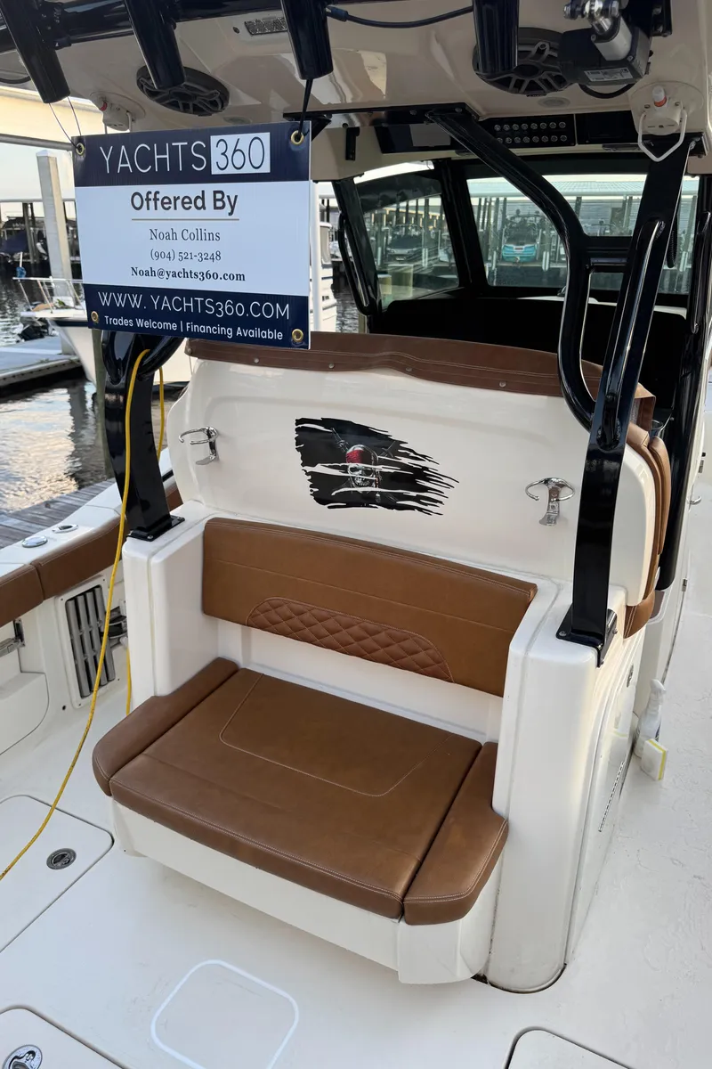 Slide: The Image of 2021 Scout 330 LXF boat with brown seating and Yachts360 sale sign. - 72