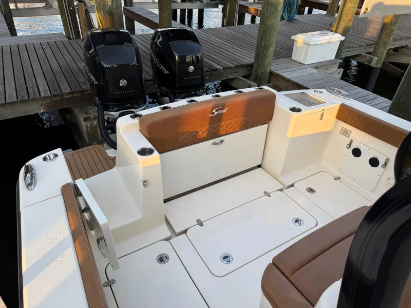 Slide: The Image of 2021 Scout 330 LXF boat interior with dual Mercury engines at dock. - 77