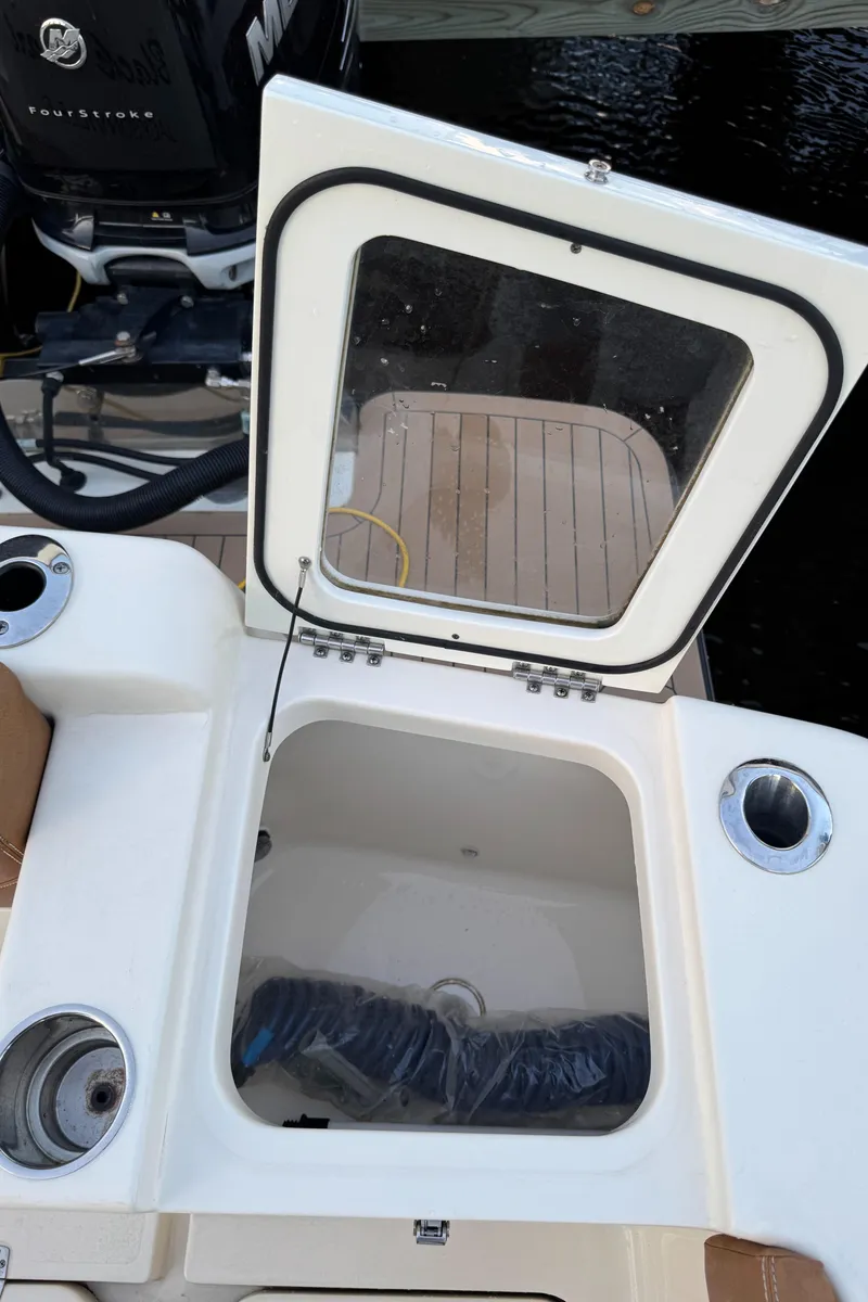 Slide: The Image of 2021 Scout 330 LXF boat with open storage compartment and visible engine. - 78