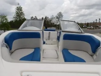 Slide: The Image of 2004 Mariah SK-10 boat interior with blue and white seating, under cloudy sky. - 3