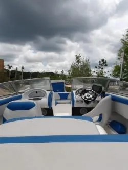 Slide: The Image of 2004 Mariah SK-10 boat interior with blue and white seating under cloudy skies. - 6