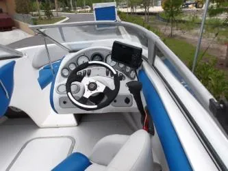 Slide: The Image of 2004 Mariah SK-10 boat cockpit with steering wheel and blue-white seating. - 7
