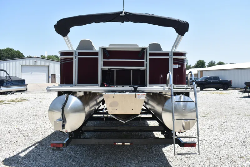 Slide: The Image of 2024 SunChaser Geneva 20 Fish 4 pontoon boat, rear view, parked on gravel lot. - 4