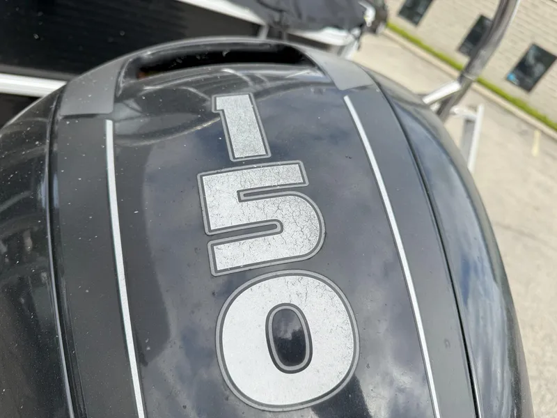 Slide: The Image of Close-up of a 150 HP outboard motor on a 2016 Sweetwater Premium Edition 240 SD. - 14