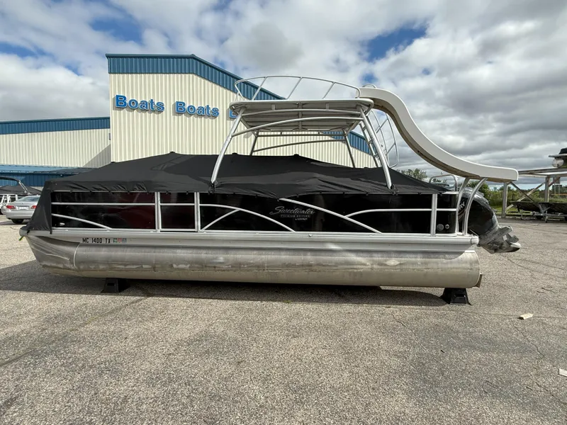 Slide: The Image of 2016 Sweetwater Premium Edition 240 SD pontoon boat with slide, parked outside a dealership. - 2