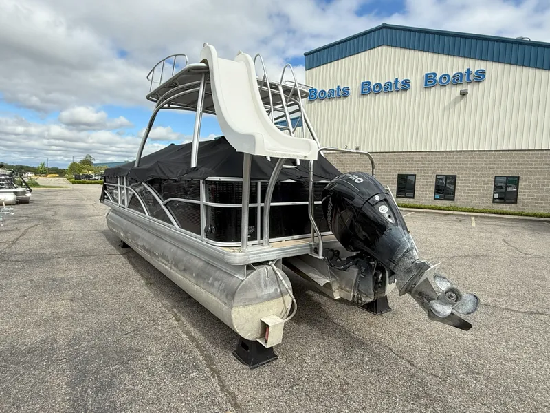 Slide: The Image of 2016 Sweetwater Premium Edition 240 SD pontoon boat with slide, parked near a boat dealership. - 4