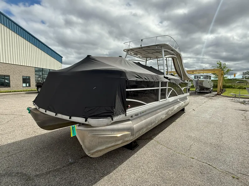 Slide: The Image of 2016 Sweetwater Premium Edition 240 SD pontoon boat with cover, parked outdoors. - 5
