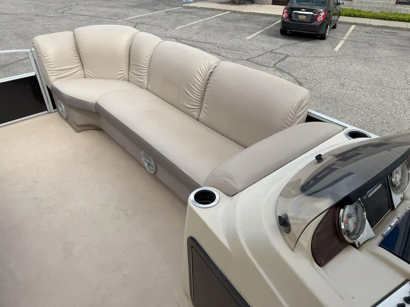 Slide: The Image of 2016 Sweetwater Premium Edition 240 SD boat interior with beige seating and dashboard. - 7