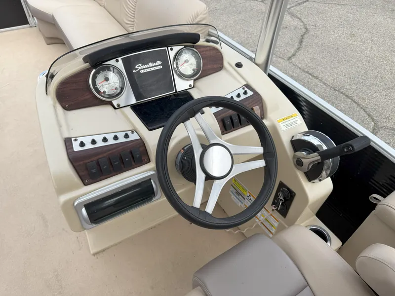 Slide: The Image of Steering console of a 2016 Sweetwater Premium Edition 240 SD boat with gauges and controls. - 9