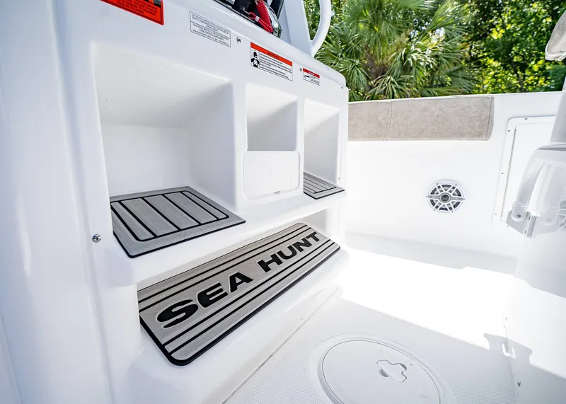 Slide: The Image of 2026 Sea Hunt Ultra 305 SE boat interior with storage compartments and branded mat. - 23
