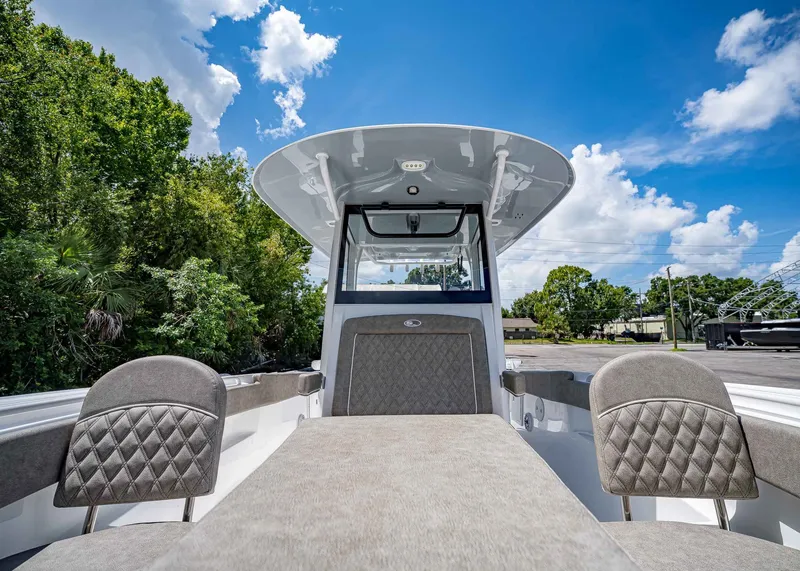 Slide: The Image of 2026 Sea Hunt Ultra 305 SE boat interior with plush seating under a clear blue sky. - 33