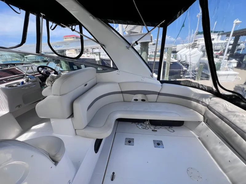 Slide: The Image of 2005 Chaparral Signature 350 boat interior with white seating and helm, docked at marina. - 14