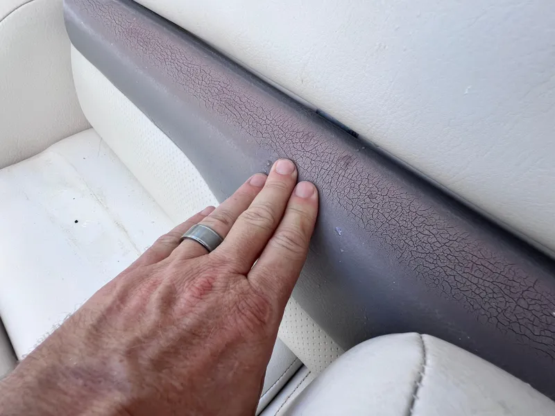 Slide: The Image of Hand touching cracked upholstery on 2005 Chaparral Signature 350 boat seat. - 29