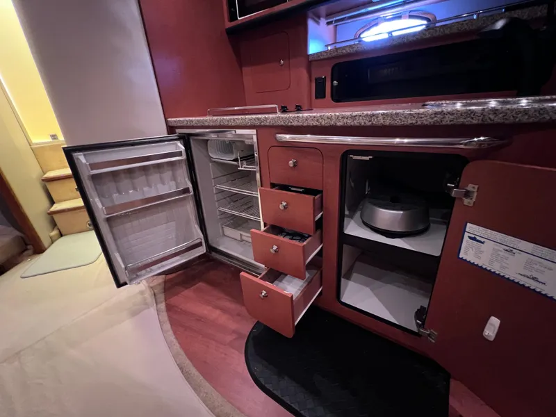 Slide: The Image of 2005 Chaparral Signature 350 interior kitchen with open fridge, drawers, and cabinets. - 42
