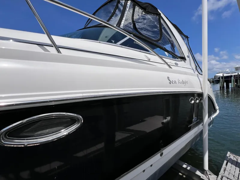 Slide: The Image of 2005 Chaparral Signature 350 boat docked, featuring sleek design and "Sea Knight" name. - 5