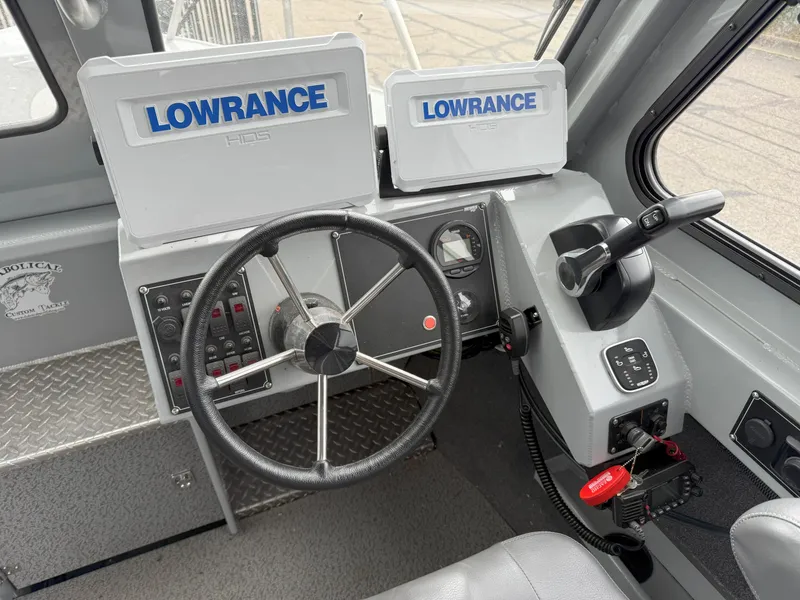Slide: The Image of 2023 Hewescraft 240 Ocean Pro ET HT boat dashboard with Lowrance electronics and steering wheel. - 11
