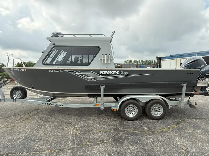 Slide: The Image of 2023 Hewescraft 240 Ocean Pro ET HT boat on trailer, parked outdoors. - 2