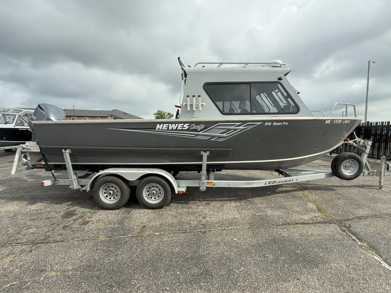 Slide: The Image of 2023 Hewescraft 240 Ocean Pro ET HT boat on trailer under cloudy sky. - 3