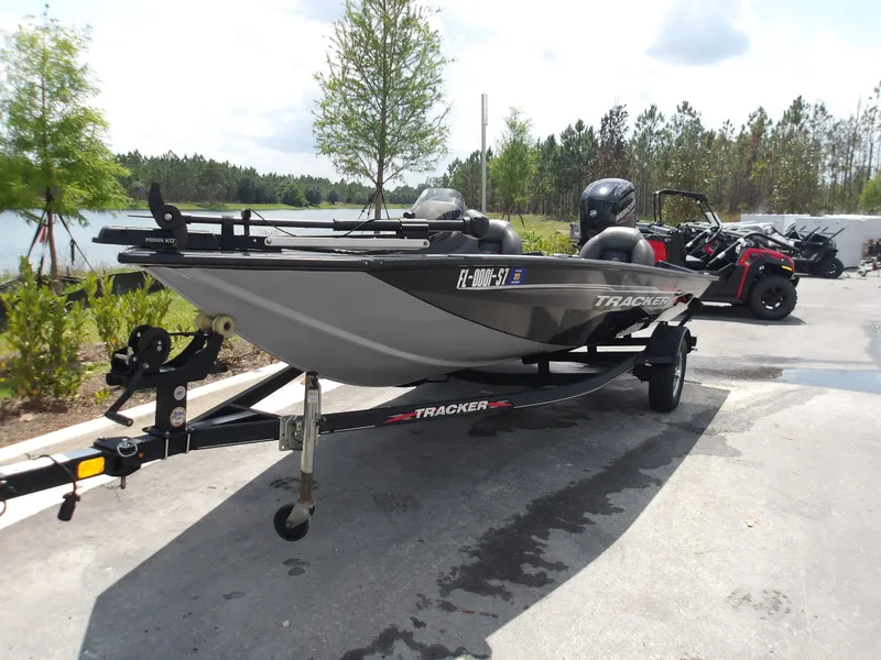 The Image of 2021 Tracker Pro Team 175 TXW boat on trailer, parked near a lake. - 0