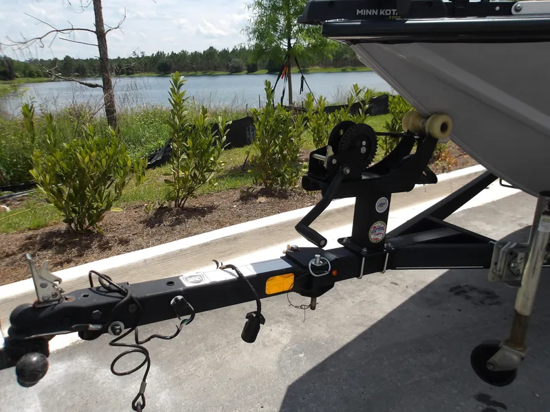 Slide: The Image of 2021 Tracker Pro Team 175 TXW boat trailer near a scenic lake. - 3