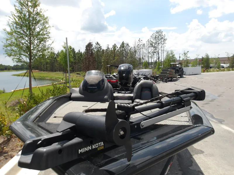 Slide: The Image of 2021 Tracker Pro Team 175 TXW boat with Minn Kota Edge motor, parked near a lake. - 4