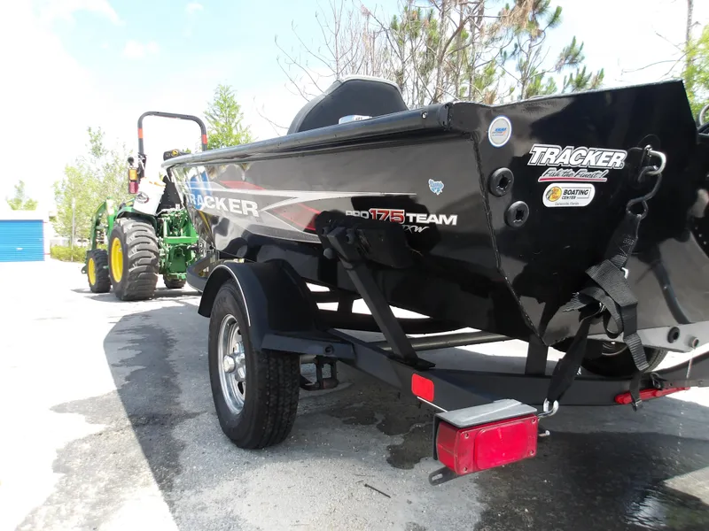 Slide: The Image of 2021 Tracker Pro Team 175 TXW boat on trailer, parked outdoors near a tractor. - 7