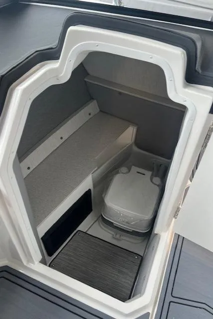 Slide: The Image of 2025 Cobalt R6 Surf boat interior with compact cabin and portable toilet. - 11